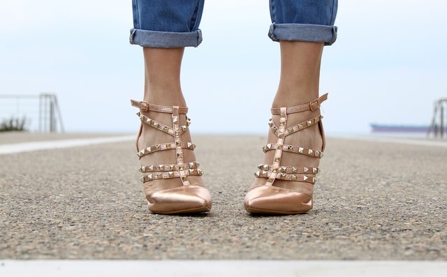 I piedi in queste scarpe oro della collezione Valentino Rockstud sono con le punte rivolte all'aiunterno. Un difetto diffuso che implica un portamento sbagliato che si può correggere già con una lezione di Portamento.