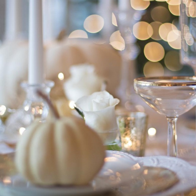 Tovaglia bianca come i piatti zucche e rose bianche come le candele e un tocco di oro per una tavola classica ispirata all'autunno.  