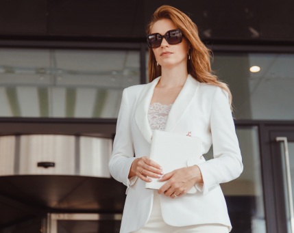 Una donna molto elegante che indossa liconico tailleur-bianco. Classe e stile.